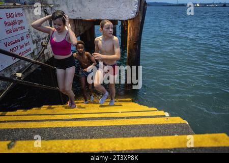 Enfants sautant dans la mer, Cobh, port de Cork, comté de Cork, Irlande, Royaume-Uni. Banque D'Images