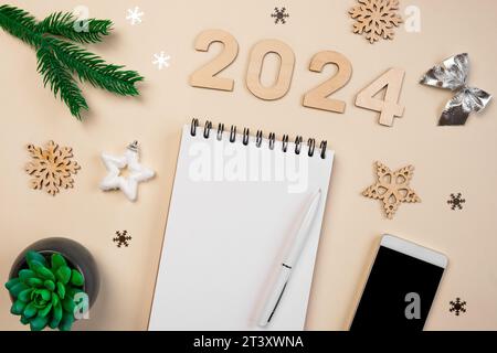 Objectifs de la nouvelle année 2024. Liste des tâches. Carnet vide au bureau avec décoration des fêtes. Vue de dessus. Création d'un plan, résolution. Nouvelle vie, Start Up, Beginning Banque D'Images