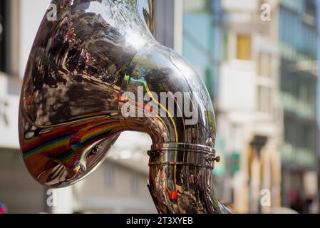 Haut de l'instrument de musique tuba gros plan avec reflet de la rue et des gens Banque D'Images