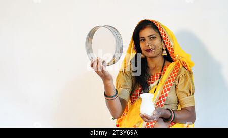 Jeune femme indienne célébrant karwa chauth en costume traditionnel avec plein de bonheur Banque D'Images