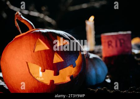 Halloween Jack-o-lanterne sur le cimetière au sol la nuit. Lumière de bougie, fumée de brouillard Banque D'Images