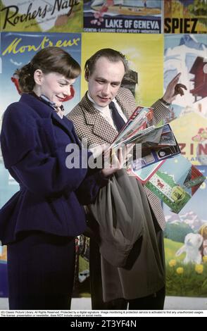 Les acteurs et le couple marié Anita Björk et Olof Bergström. Ils sont photographiés devant des affiches de destinations européennes telles que Montraeux et le lac de Genève. Ils lisent des brochures de voyage et des catalogues de voyage ensemble. Peut-être pour planifier des vacances ou pour être curieux de savoir ce que les différentes destinations peuvent offrir. Dans les années 1950, le voyage européen était quelque chose de tout à fait nouveau, à cette époque, ils ont commencé à organiser des voyages en bus vers les villes européennes et à la fin des années 1950, les premiers voyages charter par avion ont vu le jour. Suède en 1950 Banque D'Images