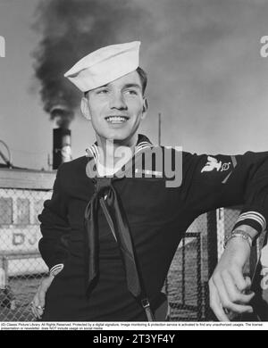 Visite de la flotte américaine le 1954 août. Un marin américain à Stockholm en liaison avec le navire USS Baltimore de la Sixième flotte américaine à laquelle il appartient, est en visite dans la capitale suédoise. Le nom du marin est Ronald Eugene Henn de Warren, Ohio USA, né le 29 décembre 1931, mort le 26 décembre, 2000. il pose pour le photographe portant son uniforme et son chapeau et avec un sourire charmant. Suède 1954. Anders Svahn Banque D'Images