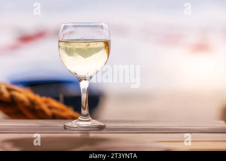 Glasse de vin blanc sur la table en bois, café de la côte, fond de ferme d'huîtres Banque D'Images