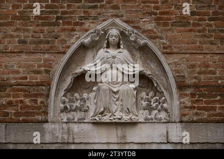 Sculpture de la Vierge de la Miséricorde (italien : Madonna della Misericordia) sur la façade de l'église San Toma à Venise. VENISE - 5 MAI 2019 Banque D'Images