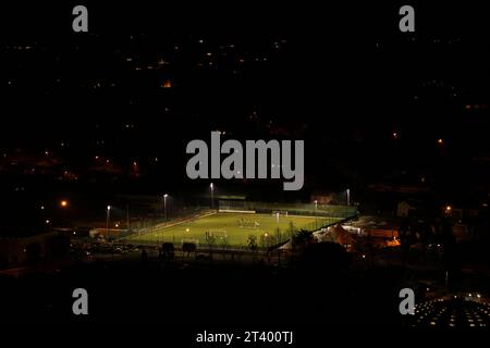 Terrain de football ou terrain de football la nuit asseyez-vous devant des lampes artificielles entourées de collines sombres. Concept pour le sport la nuit, jouer à travers n'importe quoi Banque D'Images