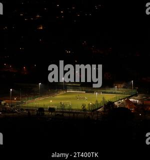 Terrain de football ou terrain de football la nuit asseyez-vous devant des lampes artificielles entourées de collines sombres. Concept pour le sport la nuit, jouer à travers n'importe quoi Banque D'Images