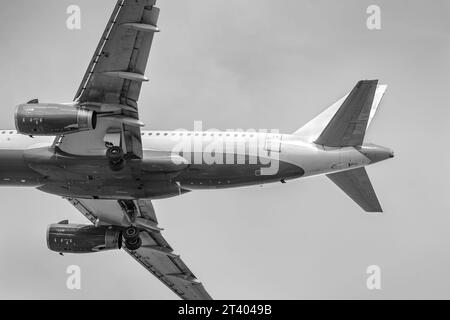 Avion de passagers se préparant à atterrir, vue de dessous. Avion volant. Avion Airbus. Photo noir et blanc. Banque D'Images