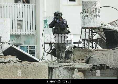 (231027) -- TEL AVIV, 27 octobre 2023 (Xinhua) -- un membre des forces de sécurité israéliennes inspecte un bâtiment endommagé lors d'une attaque à la roquette depuis Gaza, à tel Aviv, Israël, le 27 octobre 2023. Les Forces de défense israéliennes (FDI) étendent leurs opérations terrestres à Gaza vendredi soir, dans la continuité de l’offensive menée ces derniers jours, a déclaré le porte-parole de FDI Daniel Hagari. Pendant ce temps, des factions palestiniennes armées ont tiré des roquettes sur des villes israéliennes en représailles, selon les médias israéliens. (Gideon Markowicz/JINI via Xinhua) Banque D'Images