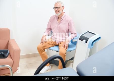 Homme âgé subissant une procédure de physiothérapie pour stimuler les muscles du plancher pelvien Banque D'Images