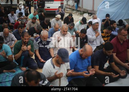 Des Palestiniens vus près d’une ambulance endommagée, alors qu’ils participent à la prière du vendredi midi dans l’allée de l’entrée d’urgence de l’hôpital Nasser à Khan Yunis, dans le sud de la bande de Gaza, au milieu des combats en cours entre Israël et le groupe palestinien Hamas. Des milliers de civils, Palestiniens et Israéliens, sont morts depuis le 7 octobre 2023, après que des militants palestiniens du Hamas basés dans la bande de Gaza sont entrés dans le sud d’Israël dans une attaque sans précédent déclenchant une guerre déclarée par Israël au Hamas avec des bombardements de représailles sur Gaza. (Photo Ahmed Zakot/SOPA Images/Sipa USA) Banque D'Images