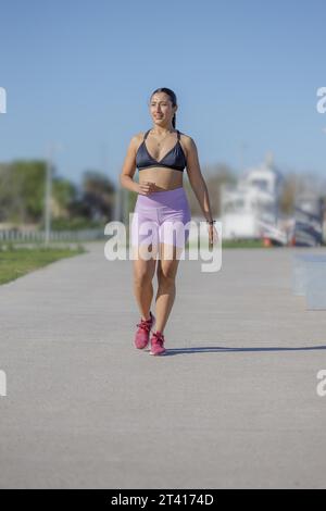 Fille latine en entraînement de vêtements de sport dans un parc public. Banque D'Images