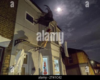 Sheerness, Kent, Royaume-Uni. 27 octobre 2023. UK Météo : la Lune presque pleine de Hunter vue tard ce soir avec des «fantômes» d'Halloween suspendus d'une maison à Sheerness, Kent. Crédit : James Bell/Alamy Live News Banque D'Images