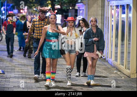 Broad Street, Birmingham, 27 octobre 2023 - des milliers de fêtards ont frappé Broad Street à Birmingham le vendredi 27e soir. Les fêtards se sont habillés en diables, policiers coquins et autres tenues effrayantes alors qu'ils faisaient leur chemin le long de la tristement célèbre bande de discothèque. La police était en force et un homme a été menotté et conduit dans un fourgon de police en attente. Les clubbers étaient principalement de bonne humeur malgré les températures chutant en chiffres uniques avec certains portant des tenues très révélatrices. D'autres costumes comprenaient des charachers de dessins animés, des sorcières et des zombies tachés de sang faux. Crédit : Arrêter presse Media/Alamy Banque D'Images