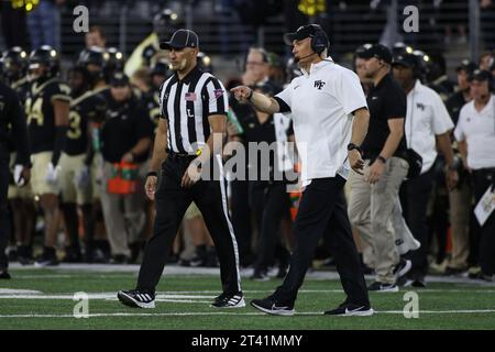 Winston-Salem, Caroline du Nord, États-Unis. 21 octobre 2023. Dave Clawson, entraîneur-chef des diacons démoniaques de Wake Forest, parle à un arbitre entre les matchs de football de la NCAA entre les Panthers de Pittsburgh et les diacons démoniaques de Wake Forest au Allegacy Federal Credit Union Stadium de Winston-Salem, en Caroline du Nord. Jonathan Huff/CSM/Alamy Live News Banque D'Images