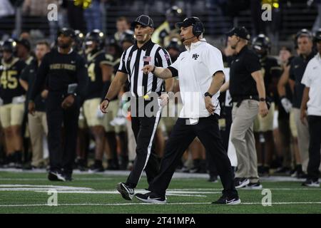Winston-Salem, Caroline du Nord, États-Unis. 21 octobre 2023. Dave Clawson, entraîneur-chef des diacons démoniaques de Wake Forest, parle à un arbitre entre les matchs de football de la NCAA entre les Panthers de Pittsburgh et les diacons démoniaques de Wake Forest au Allegacy Federal Credit Union Stadium de Winston-Salem, en Caroline du Nord. Jonathan Huff/CSM/Alamy Live News Banque D'Images