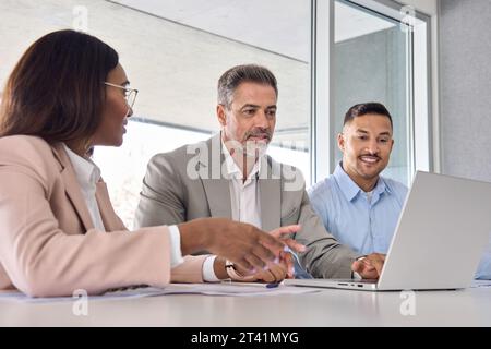 Équipe de cadres internationaux utilisant un ordinateur portable discutant de données numériques. Banque D'Images