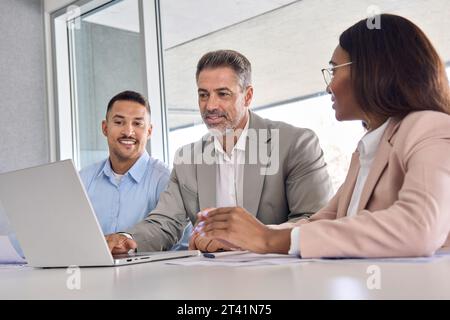 Équipe de cadres internationaux utilisant un ordinateur portable discutant de données numériques. Banque D'Images