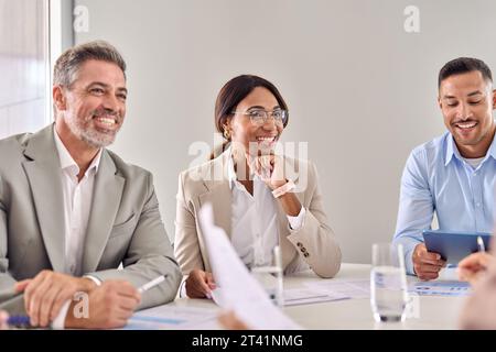 Heureux dirigeant de femme d'affaires communiquant pendant la réunion de groupe d'affaires. Banque D'Images