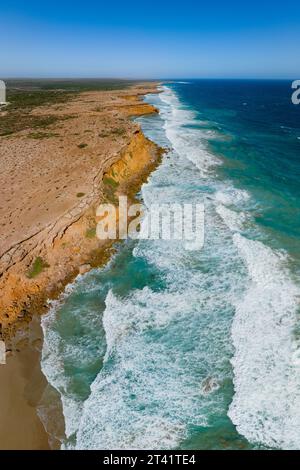 Vue aérienne le long de falaises accidentées au-dessus de grandes vagues à venus Bay sur la péninsule d'Eyre en Australie méridionale Banque D'Images