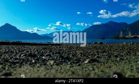 Une vue aérienne imprenable sur un paysage côtier avec une plage avec des affleurements rocheux au premier plan et un bateau amarré au loin Banque D'Images