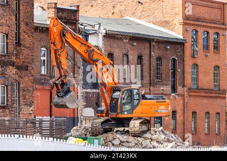 Excavatrice de démolition en face des bâtiments historiques en brique, vue sur la ville Berlin, Allemagne Banque D'Images