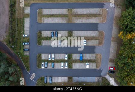 Bandenitz, Allemagne. 27 octobre 2023. Seules quelques voitures sont garées dans un parking pour les navetteurs à la bretelle de Hagenow sur l'autoroute A24 en direction de Hambourg (photo aérienne prise avec un drone). Les habitants du quartier Ludwigslust-Parchim acceptent les trajets les plus longs pour travailler en Allemagne. Selon les calculs de l'Institut fédéral de recherche sur la construction, les affaires urbaines et le développement spatial (BBSR) à Bonn, le trajet moyen aller simple là-bas en 2022 était de 28,6 kilomètres par jour. Crédit : Jens Büttner/dpa/Alamy Live News Banque D'Images