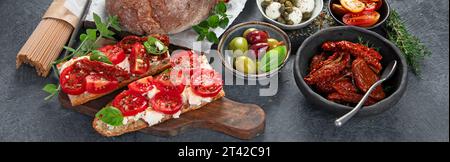 Encas italiens antipasti. Bruschettas savoureux au fromage, tomates séchées au soleil. Concept alimentaire traditionnel. Banque D'Images