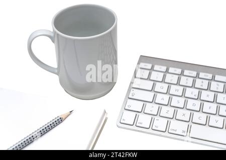 une tasse de café sur le bureau, entre un clavier et un presse-papiers sur un fond transparent Banque D'Images