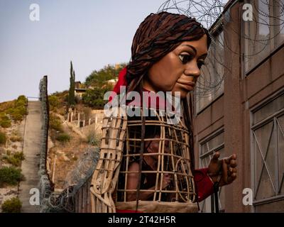 Nogales, Arizona, États-Unis. 27 octobre 2023. Little Amal, la marionnette de 12 pieds d’une réfugiée syrienne se reflète sur le mur frontalier en construction derrière elle, qui sépare les États-Unis et le Mexique. Des rouleaux de fil concertina recouvrent la barrière de béton et d'acier qui monte la colline derrière elle. (Image de crédit : © Sue Dorfman/ZUMA Press Wire) USAGE ÉDITORIAL SEULEMENT! Non destiné à UN USAGE commercial ! Banque D'Images