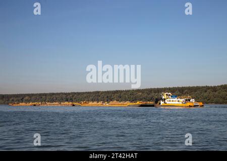 Un remorqueur pousse des barges combinées chargées de sable le long du Danube Banque D'Images