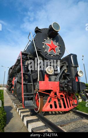 Un vieux train à vapeur noir et rouge exposé. Derrière le complexe du musée Stone Chronicle à Bakou, Azerbaïdjan. Banque D'Images