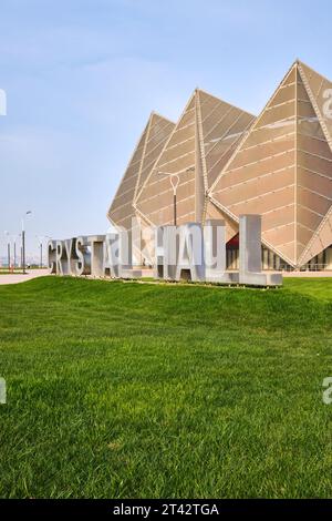 Une vue de l'extérieur dentelé avec un grand panneau découpé sur l'herbe avant. Au bâtiment de l'arène Baku Crystal Hall à Bakou, Azerbaïdjan. Banque D'Images