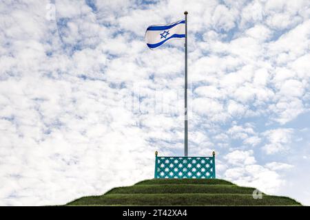 28 octobre 2023, Brandebourg, Branitz : un drapeau israélien flotte au-dessus de la pyramide terrestre dans le parc Fürst-Pückler. En signe de solidarité avec les victimes de l’attentat terroriste en Israël et à l’occasion du concert de solidarité au Théâtre d’État de Cottbus le 31 octobre, le Parc du Musée du Prince Pückler et la Fondation du Château de Branitz démontrent également leur solidarité avec les Juifs de ce pays et du monde entier. Le prince Pückler a préconisé l'égalité des droits pour les Juifs en Prusse au 19e siècle. Le 30 octobre est son anniversaire. A cette occasion, un drapeau est traditionnellement hissé à la pyramide du parc Branitz. Banque D'Images