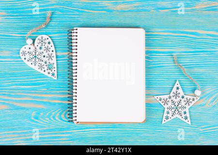 Composition de Noël et nouvel an. Décorations de Noël, et cahier vierge sur fond en bois bleu. Pose à plat, vue de dessus, espace de copie. Banque D'Images