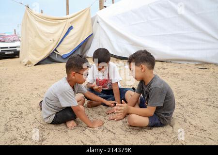 Gaza. 27 octobre 2023. Des enfants palestiniens sont vus dans un abri temporaire dans la ville de Khan Younis, dans le sud de la bande de Gaza, le 27 octobre 2023. Richard Peeperkorn, représentant du territoire palestinien occupé auprès de l'Organisation mondiale de la Santé (OMS), a déclaré vendredi au point de presse que l'OMS avait reçu jusqu'à présent des rapports faisant état de 7 045 décès, dont près de la moitié d'enfants, et de 80 482 blessés, dont 33 pour cent d'enfants. Crédit : Rizek Abdeljawad/Xinhua/Alamy Live News Banque D'Images