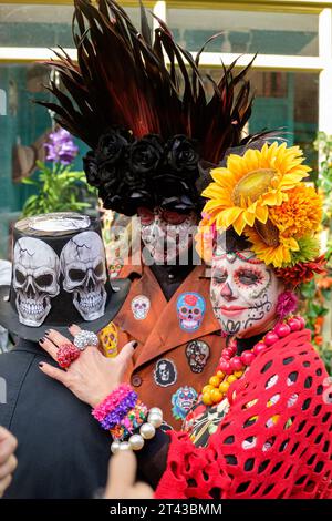 Londres, Royaume-Uni. 28 octobre 2023. Célébration de la Journée mexicaine des morts à Columbia Road, à l'est de Londres. Il est devenu un moyen de se souvenir de la culture mexicaine et implique la famille et les amis se rassemblant pour rendre hommage et se souvenir des amis et des membres de la famille qui sont décédés. Ces célébrations peuvent prendre un ton humoristique, car les célébrants se souviennent d'événements drôles et d'anecdotes sur les défunts. En ce jour, on croit que les esprits des ancêtres reviennent. Columbia Road est célèbre pour son marché aux fleurs, et les fleurs font partie intégrante de cette célébration annuelle. Crédit : Mary-lu Bakker/Alamy Live News Banque D'Images