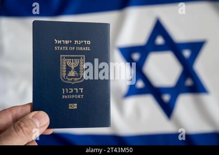 Main tient un passeport international israélien avec le drapeau israélien sur le fond Banque D'Images