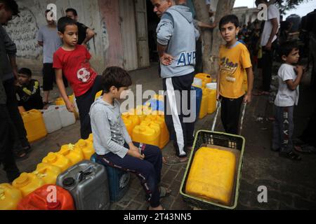 Palestiniens stan prochain jerrycans en plastique à un point de remplissage d'eau, à Rafah, dans le sud de la bande de Gaza le 28 octobre 2023..la grève israélienne se poursuit sur Gaza en raison d'une pénurie de fournitures médicales, d'eau et d'électricité, mais les frappes aériennes israéliennes ont causé des dommages substantiels à l'infrastructure du côté palestinien. Photo par Ismael Mohamad/UPI.. Banque D'Images