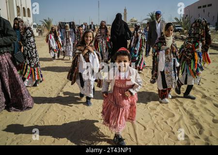 Un groupe de jeunes filles marchent en portant les costumes traditionnels des femmes de l'oasis de Siwa. Banque D'Images