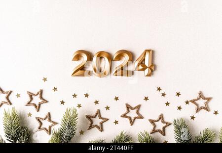 Carte de voeux - bonne année avec numéros 2024 et paillettes dorées et étoiles sur fond blanc. Concept de vacances minimal. Vue de dessus. Pose à plat Banque D'Images