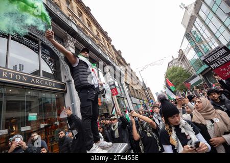 Man tient une torche alors que des milliers de manifestants pro-palestiniens se rassemblent pour une manifestation de masse à Manchester Royaume-Uni. Les manifestants ont défilé de la place Saint-Pierre dans le centre-ville. Drapeaux et banderoles ont été maintenus en altitude et des fusées éclairantes ont été larguées. Des discours ont été prononcés sur la place Saint-Pierre avant et après la marche circulaire. Photo : garyroberts/worldwidefeatures.com Banque D'Images