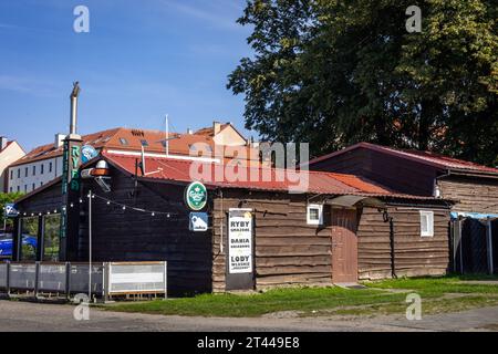 Kamien Pomorski, Pologne - 14 septembre 2023 : restaurant de poissons Karczma Marina dans une ancienne maison de pêcheurs en bois au port de la lagune de Kamien. Banque D'Images