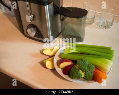 Presse-agrumes avec assiette de légumes frais. Préparation du jus de légumes Banque D'Images