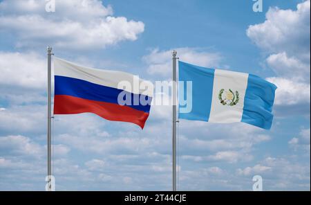 Drapeaux du Guatemala et de la Russie agitant ensemble sur un ciel nuageux bleu, concept de relation entre deux pays Banque D'Images