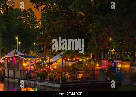 Wroclaw, Pologne - juin 25 2023 : façades de bars et restaurants modernes sur l'eau près de l'île et plein de petites lumières incandescentes autour Banque D'Images