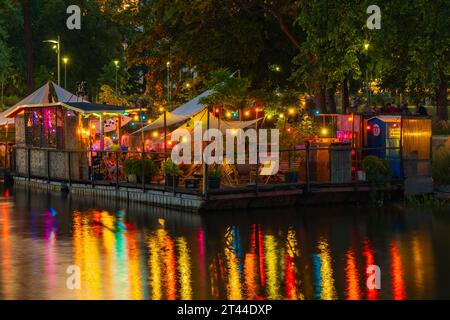Wroclaw, Pologne - juin 25 2023 : façades de bars et restaurants modernes sur l'eau près de l'île et plein de petites lumières incandescentes autour Banque D'Images