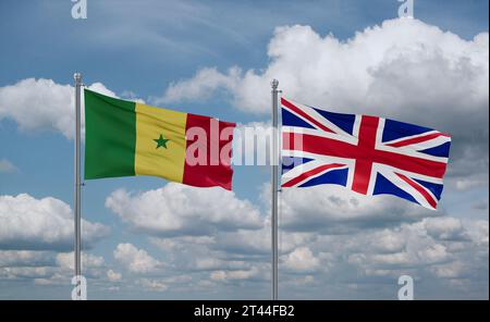 Drapeaux du Royaume-Uni et du Sénégal agitant ensemble dans le vent sur un ciel nuageux bleu, concept de relation entre deux pays Banque D'Images