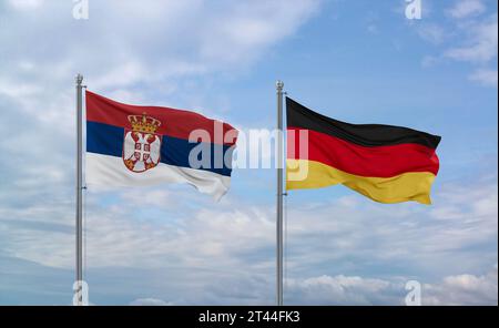 Drapeaux de l'Allemagne et de la Serbie agitant ensemble sur un ciel nuageux bleu, concept de relation entre deux pays Banque D'Images