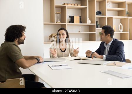 Chef d'entreprise femme confiante parlant à des employés multiethniques Banque D'Images
